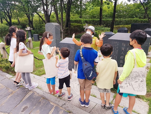 양화진 외국인 선교사 묘원에 대한 해설사의 설명을 듣는 어린이 참가자들 모습..jpg